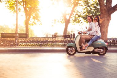 Genç çift bir scooter sürme ve having fun