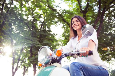 woman riding vintage scooter