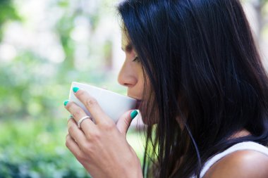 Side view portrait of a woman drinking coffee 