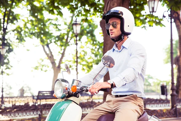 Mann mit Helm auf Motorroller unterwegs — Stockfoto