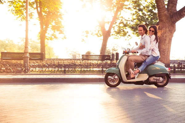 Alegre jovem casal montando uma scooter e se divertindo — Fotografia de Stock