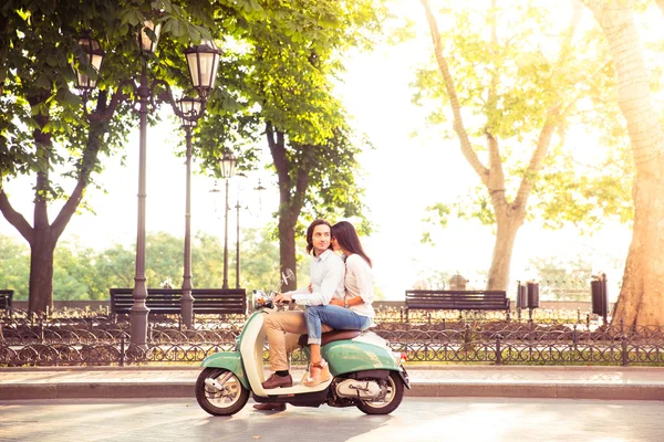 Casal na moda montando uma scooter pela manhã — Fotografia de Stock
