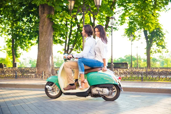 Счастливая пара едет на скутере — стоковое фото