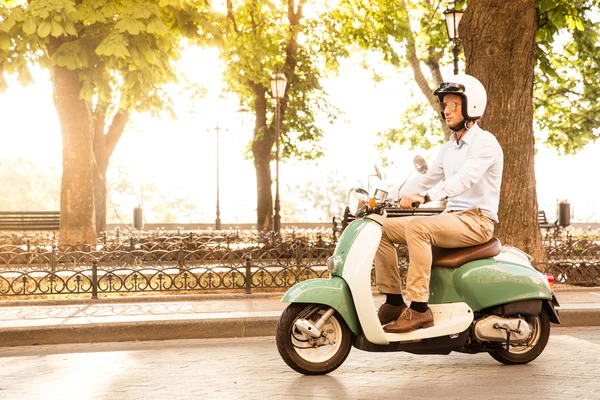 Homme à la mode conduisant un scooter dans le casque — Photo