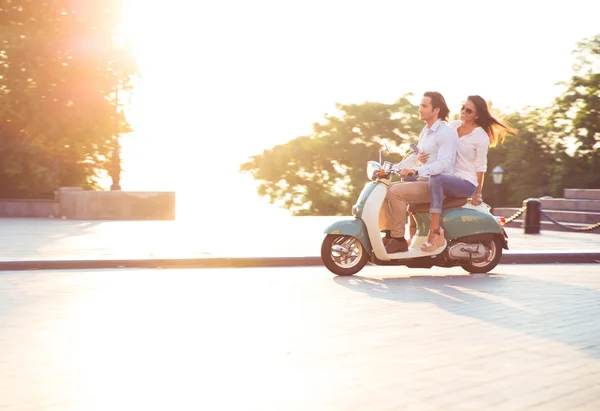 Young couple riding a scooter — Stock Photo, Image