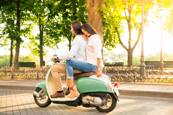 Jovem casal montando uma scooter — Fotografia de Stock