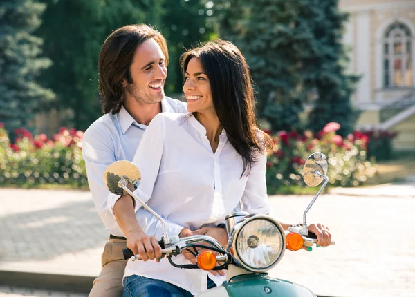 Счастливая пара флиртует на скутере — стоковое фото
