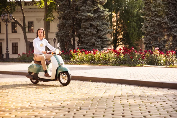 Man rijden een scooter door stad straten in de ochtend — Stockfoto