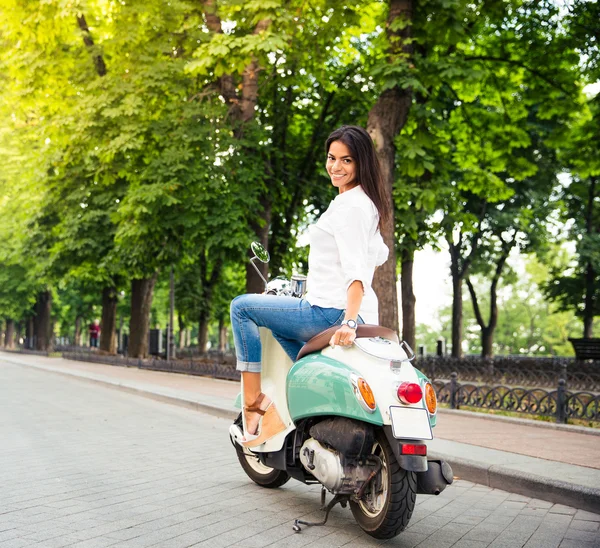 Mujer joven feliz en un scooter — Foto de Stock