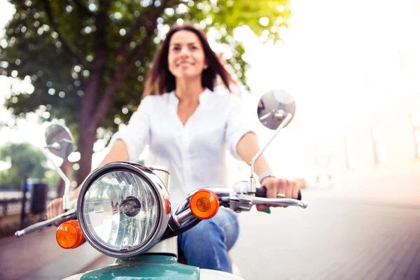 Sorridente giovane donna su uno scooter — Foto Stock