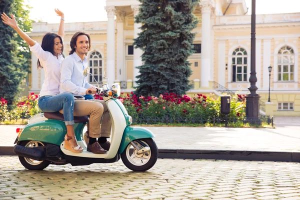 Улыбающаяся молодая пара, катающаяся на скутере — стоковое фото