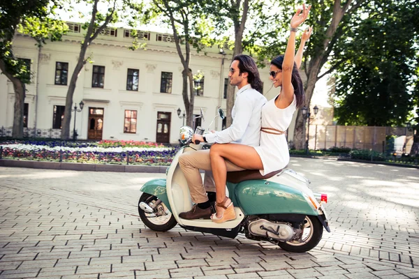 Casal feliz montando uma scooter — Fotografia de Stock