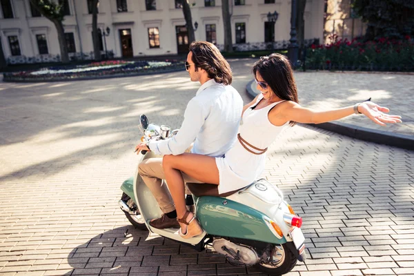 Casal feliz montando uma scooter — Fotografia de Stock