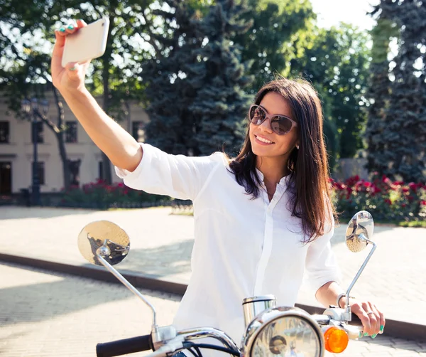 Woman on scooter making selfie photo — Stock fotografie
