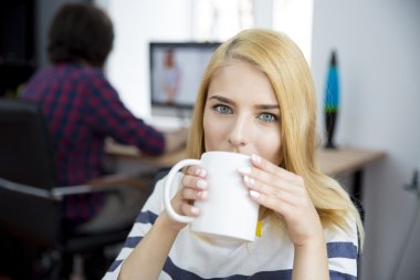 Young casual woman drinking coffee