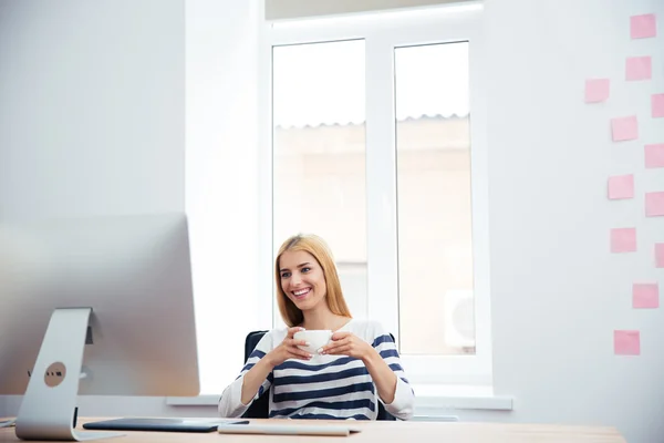 Female photo editor drinking coffee — Stock fotografie