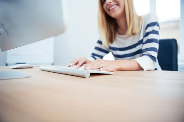 Jonge vrouw die werkt op bureaublad — Stockfoto