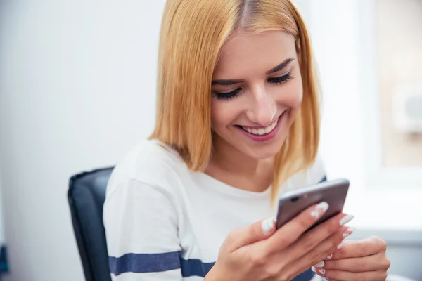 Femme utilisant un smartphone au bureau — Photo