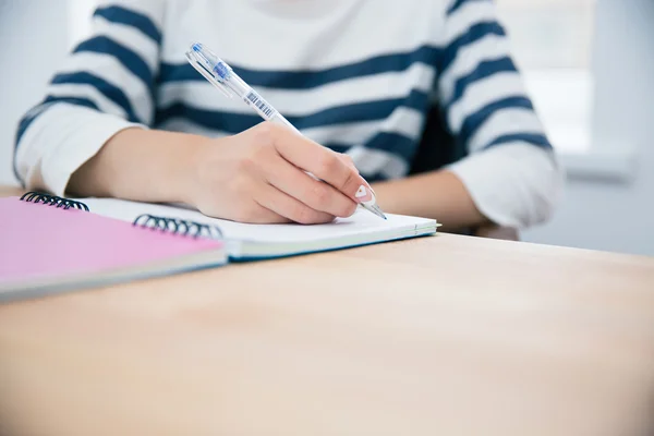 Vrouw die schrijft in een notitieblok — Stockfoto