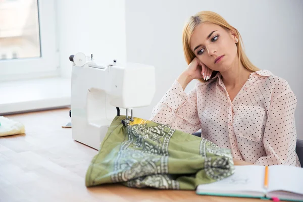 Müde Schneiderin sitzt am Tisch — Stockfoto