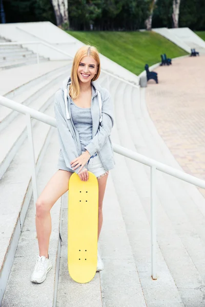 Ragazza in piedi sulle scale con skateboard — Foto Stock