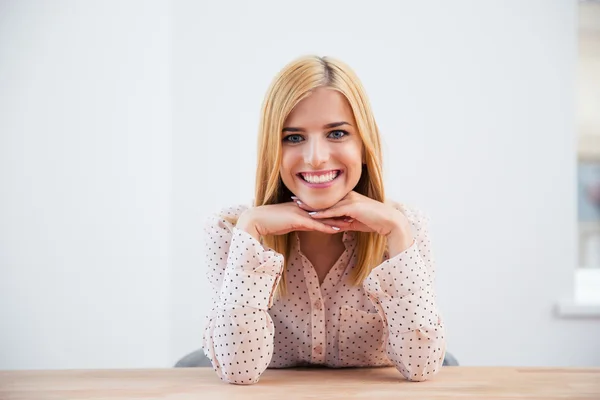Femme d'affaires blonde souriante assise au bureau — Photo