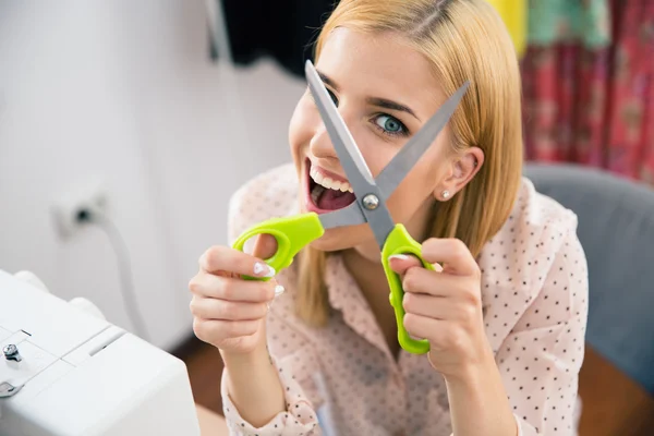 Cheerful young woman holding scissors — Stockfoto