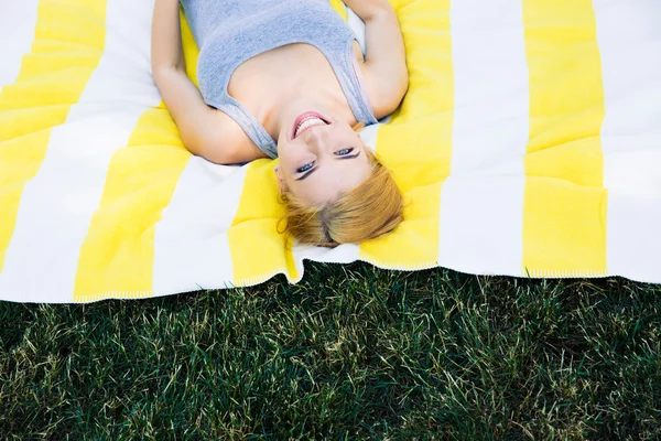 Cute smiling wmoan lying on mat — Stockfoto