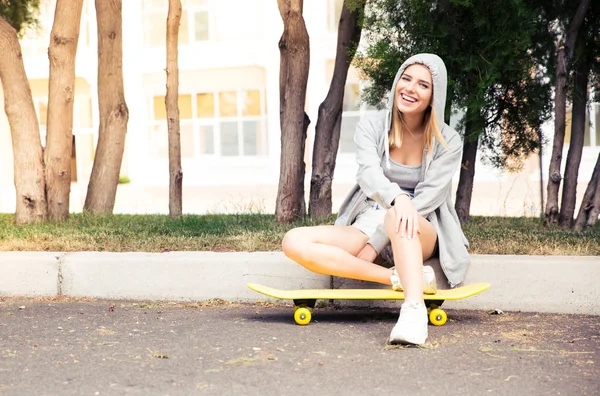 Girl resting with skateboard outdoors — Stockfoto