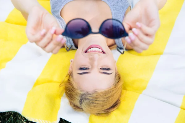Happy young woman lying on mat — ストック写真