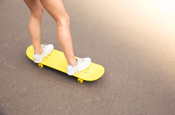 Pernas femininas no skate — Fotografia de Stock