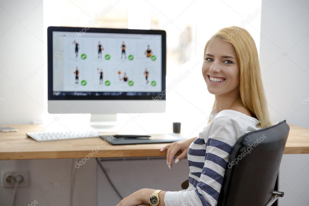 Smiling young girl sitting at her workplace