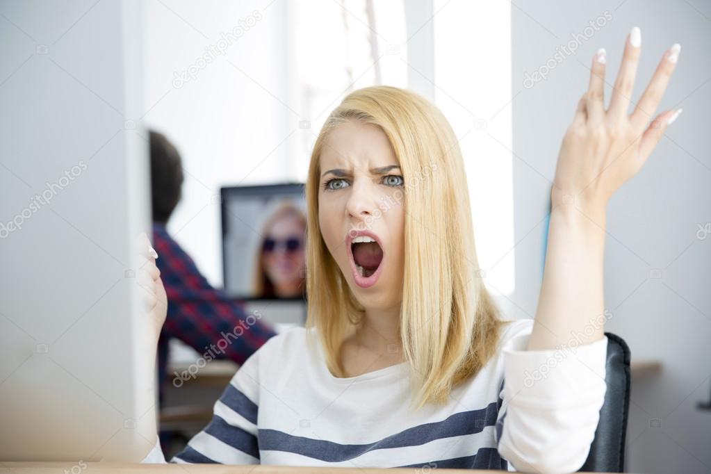 Shocked young woman working on computer