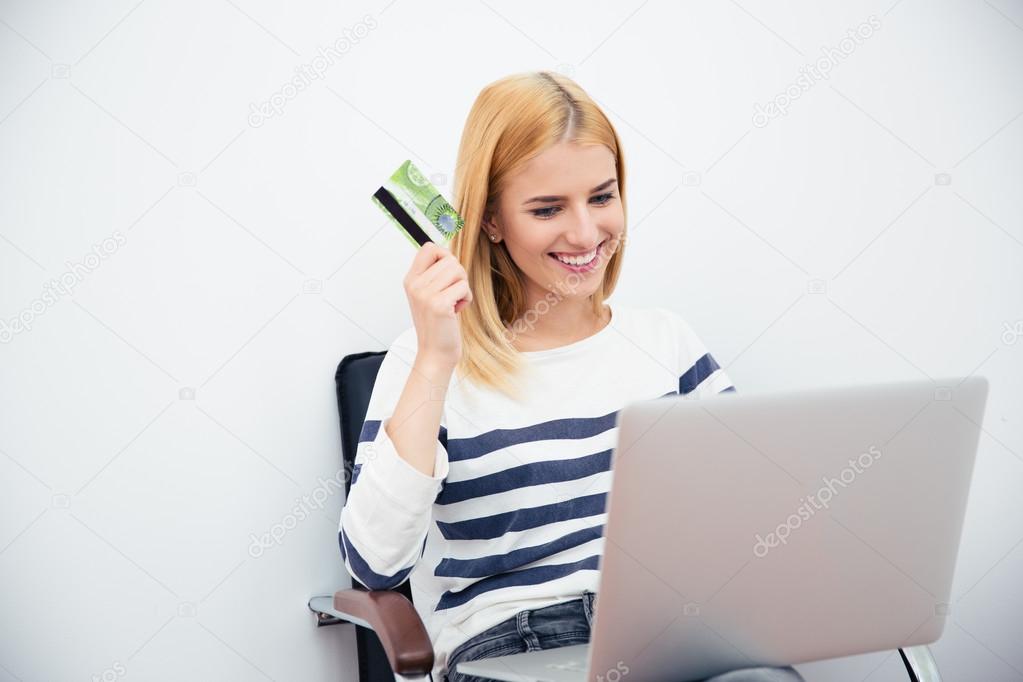 Woman holding laptop and bank card 