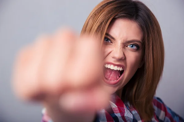 Frau schlägt mit Faust auf Kamera und schreit — Stockfoto