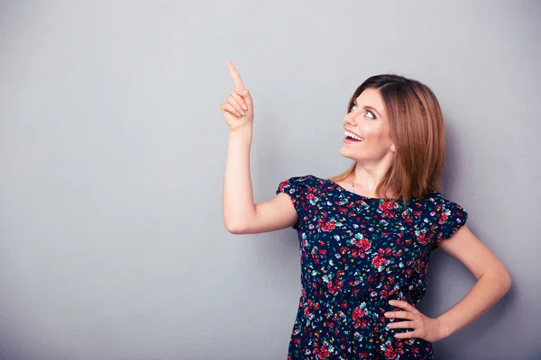 Feliz mujer reflexiva apuntando con el dedo hacia arriba — Foto de Stock