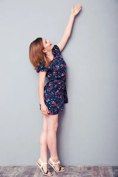 Mulher de vestido esticando a mão para cima — Fotografia de Stock
