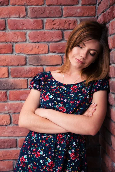 Mujer con los brazos cruzados apoyada en la pared de rotura —  Fotos de Stock