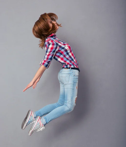 Jovem pulando isolado em um cinza — Fotografia de Stock