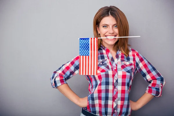 Woman holding USA flag in teeth — Stock Photo, Image