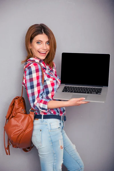 Mujer feliz mostrando pantalla portátil en blanco — Foto de Stock