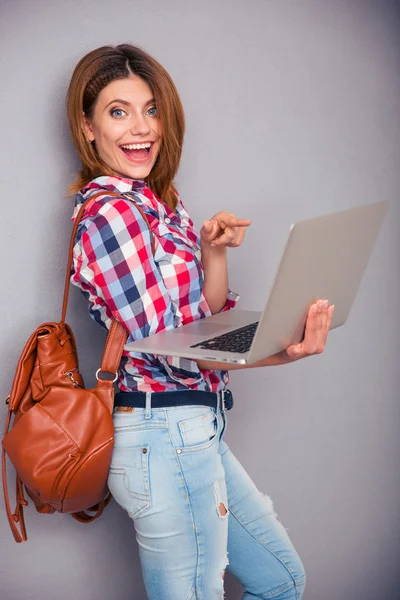 Junge Frau zeigt mit dem Finger auf Laptop-Bildschirm — Stockfoto