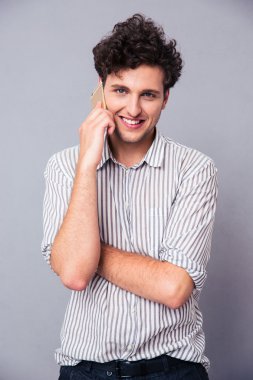 Mutlu genç adam telefonda konuşuyor.