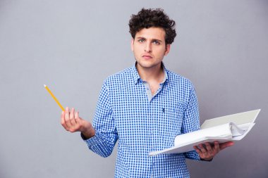 Kalem ve klasör dosyaları ile tutan adam