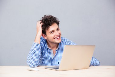 Laptop ile masada oturan mutlu adam