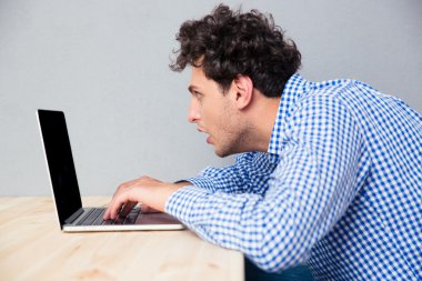 İş adamı masada oturuyor ve dizüstü bilgisayar kullanıyor.