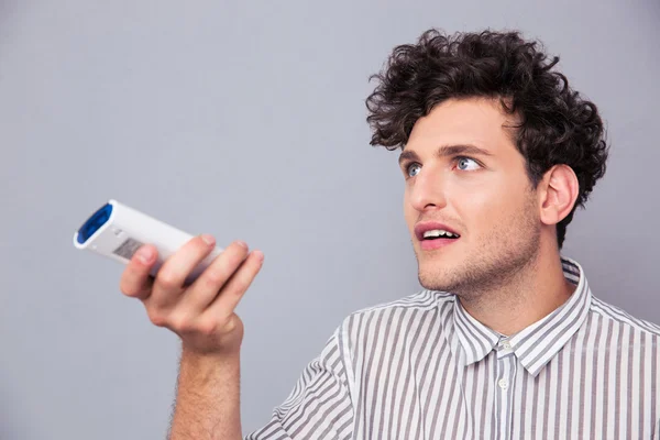 Man holding TV remote — Stock Photo, Image