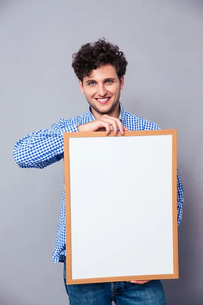 Sorrindo jovem segurando placa em branco — Fotografia de Stock