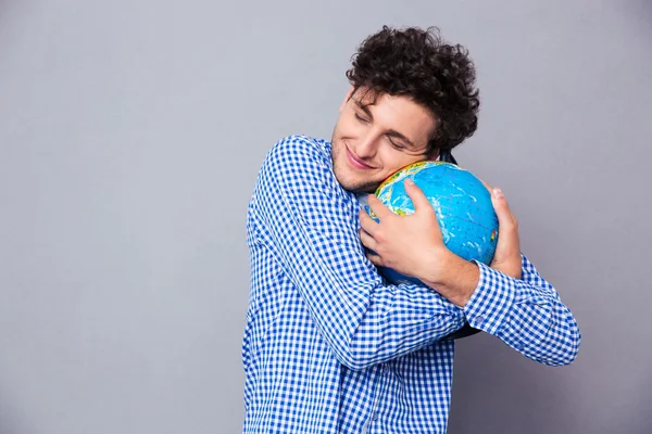 Молодой человек обнимает глобус — стоковое фото
