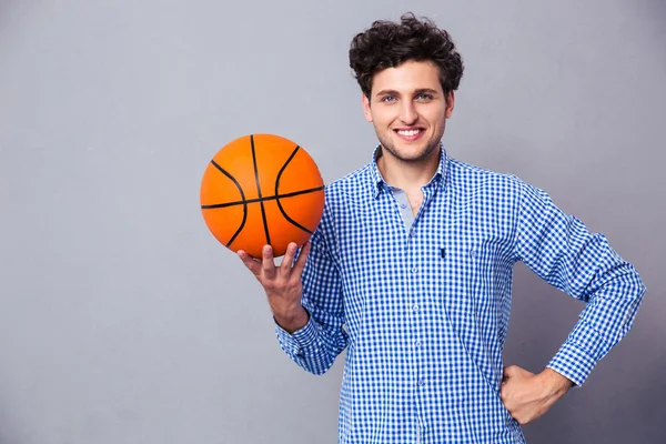 Sorrindo jovem segurando bola cesta — Fotografia de Stock